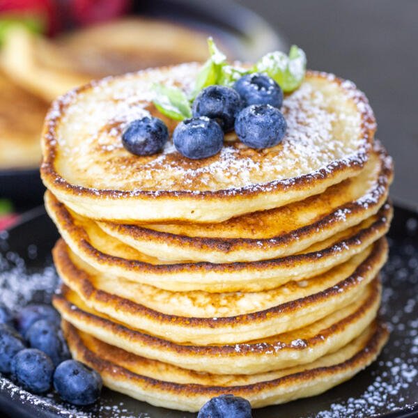 Ricotta Pancakes topped on top of each other on a plate.
