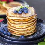 Ricotta Pancakes on top of each other with berries.