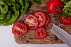 Tomatoes sliced on a cutting board.