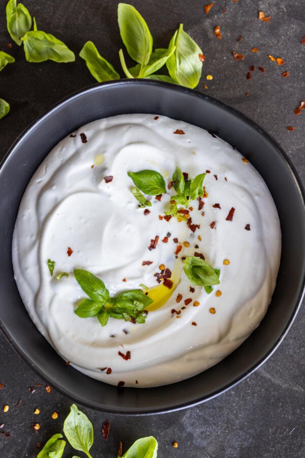 Creamy cottage cheese with herbs in a bowl.