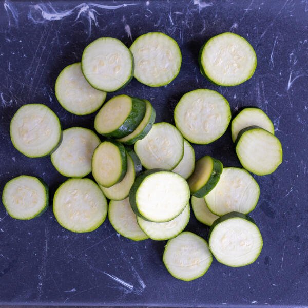 Sliced zucchini on a cutting board.