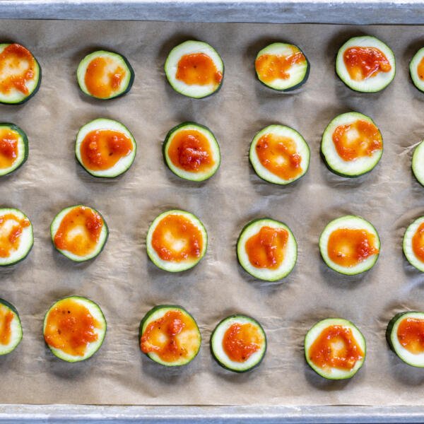 Slices of zucchini with pizza sauce.