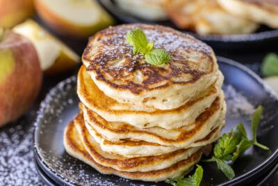 Apple Pancakes on a plate with powdered sugar.