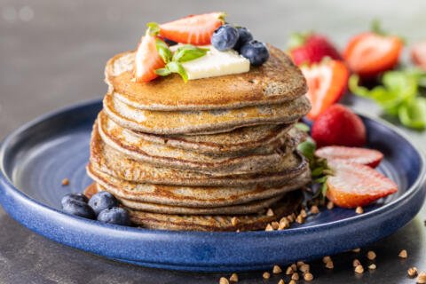 Buckwheat Pancakes on a plate with berries.