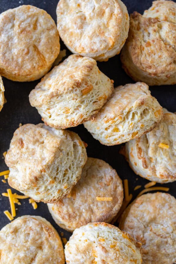 A pile of Cheddar Cheese Biscuits with cheddar cheese.