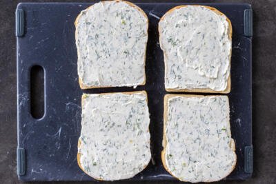 Herb cream cheese on a bread slices.