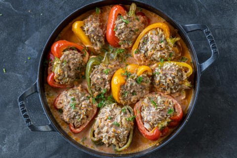 Beef Stuffed papers with sauce in a baking pan.