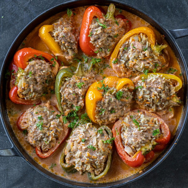 Beef Stuffed papers with sauce in a baking pan.