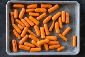 Baby carrots on a baking sheet.