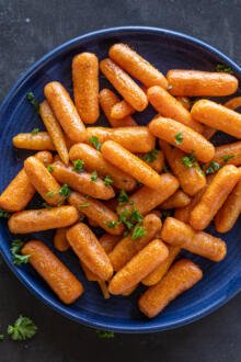 Roasted Baby Carrots in a palte with herbs.