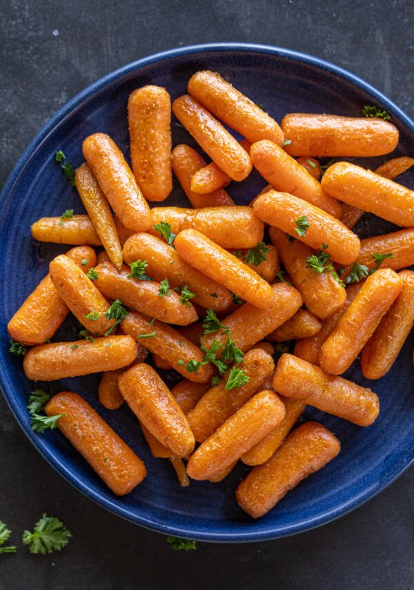 Roasted Baby Carrots in a palte with herbs. 