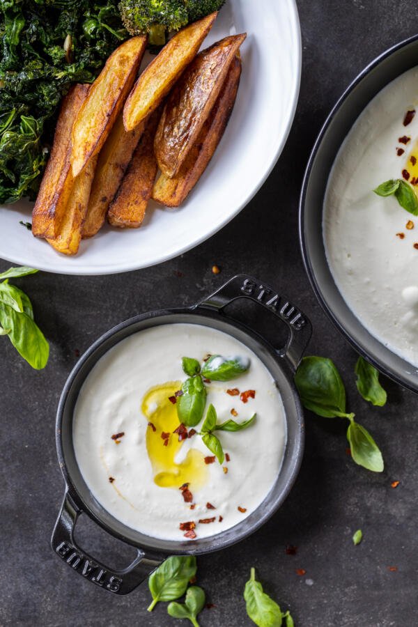 Whipped Feta Dip in a serving tray with veggies next to it.