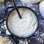 Alfredo Pizza Sauce in a pan with flour around it.