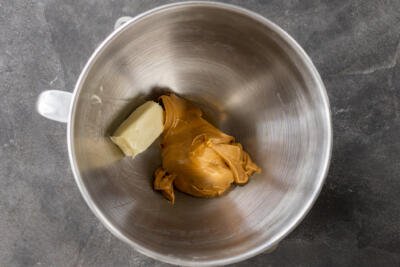 Butter and peanut butter in a mixing bowl.