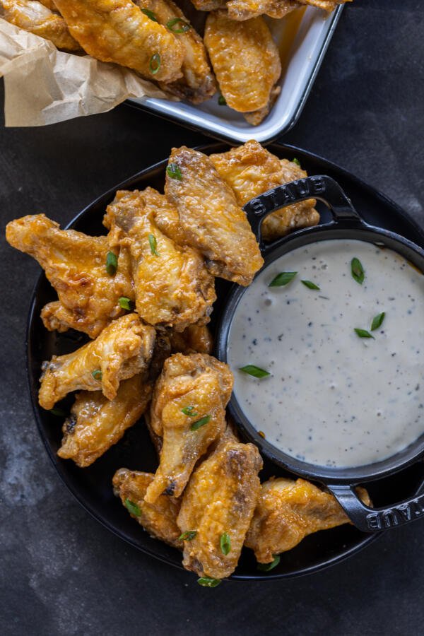 Wings on a plate with dipping sauce.