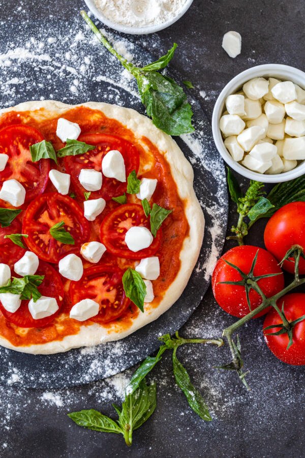 Pizza dough before baking with toppings.