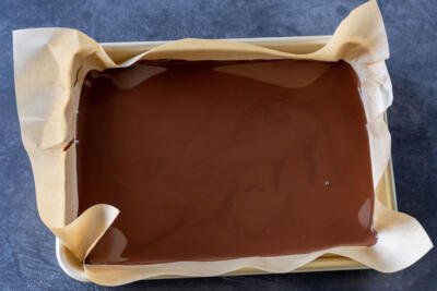 Melted dark chocolate on a baking sheet.