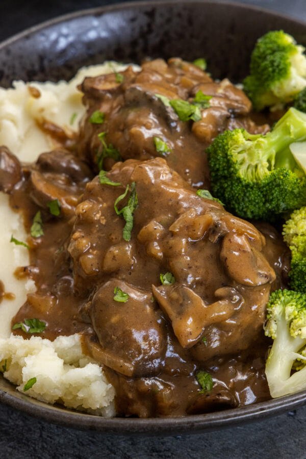 Salisbury Steak with mashed potatoes in a serving dish.