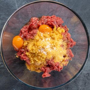 Eggs and seasoning added to the bowl with beef.