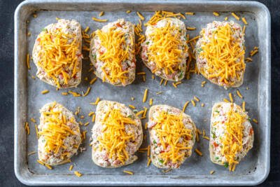 Tuna melts topped with cheese on a baking sheet.