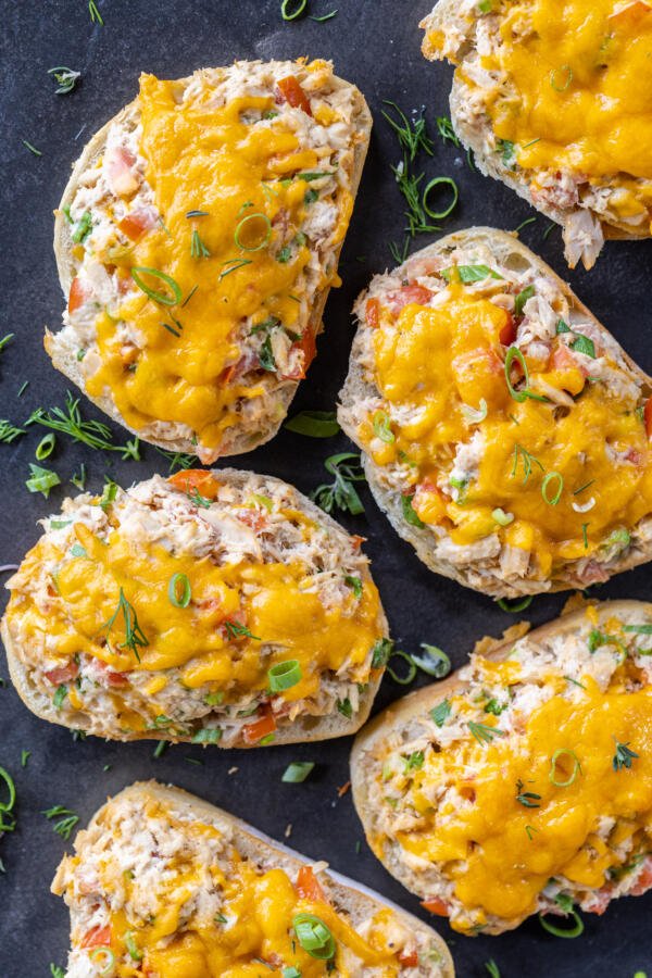 Tuna melts on a tray with herbs.