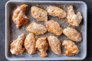 Seasoned wings with parmesan on a tray.