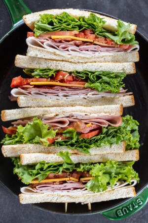 Sliced up Club Sandwiches in a pan.