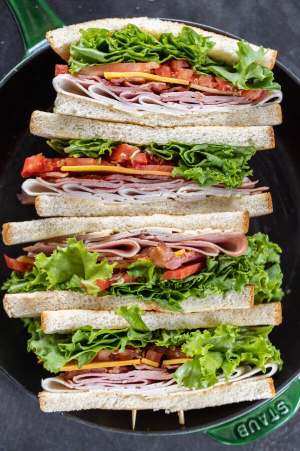 Sliced up Club Sandwiches in a pan. 