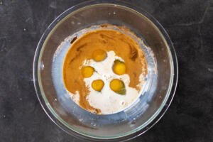 Eggs, cinnamon, vanilla and milk in a bowl.