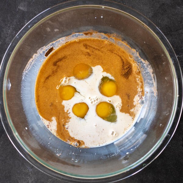 Eggs, cinnamon, vanilla and milk in a bowl.