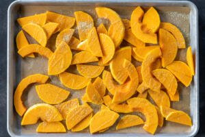 Sliced up Butternut Squash on a baking sheet.