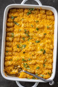 Tater Tot Breakfast Casserole in a dish with herbs.