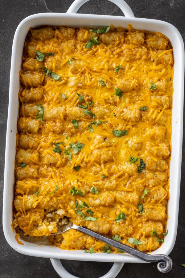 Tater Tot Breakfast Casserole in a dish with herbs. 