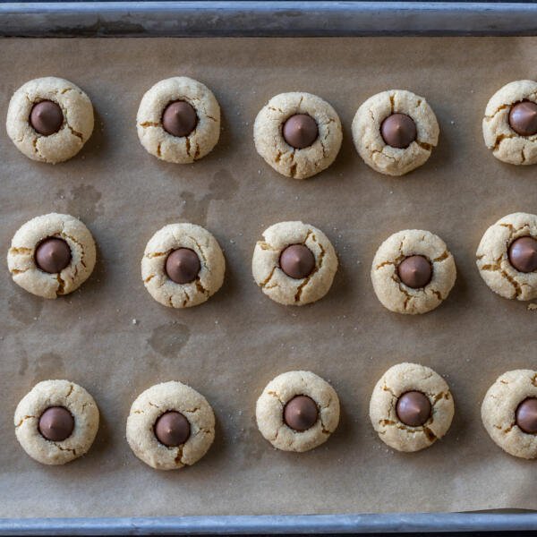 Baking sheet with baked Peanut Butter Blossoms.