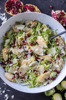 Shaved Brussels Sprout Salad with a spoon and dressing added.