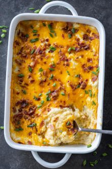 Twice Baked Potato Casserole in a pan with a spoon.