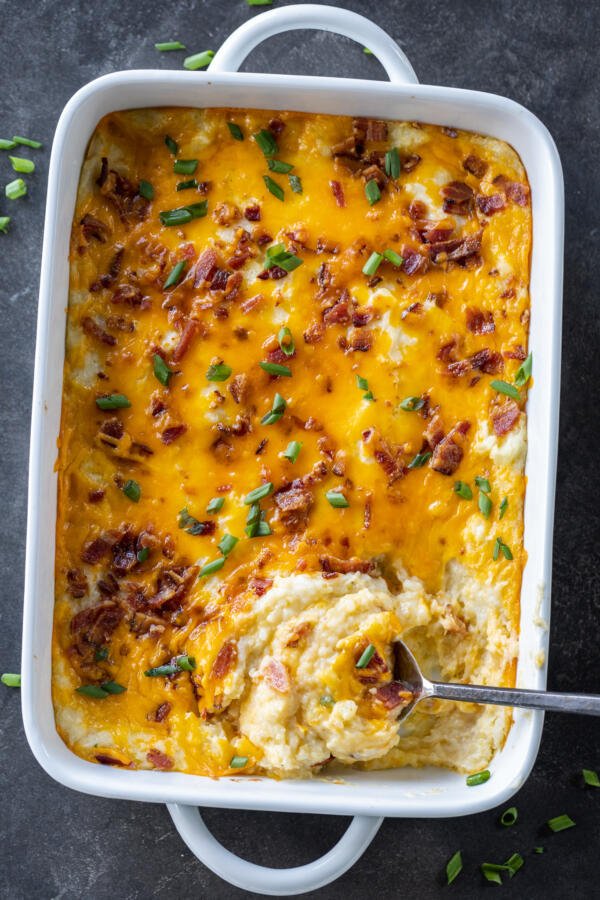 Twice Baked Potato Casserole in a pan with a spoon. 