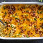Twice Baked Potato Casserole in a baking dish with a spoon.