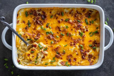 Twice Baked Potato Casserole in a baking dish with a spoon.