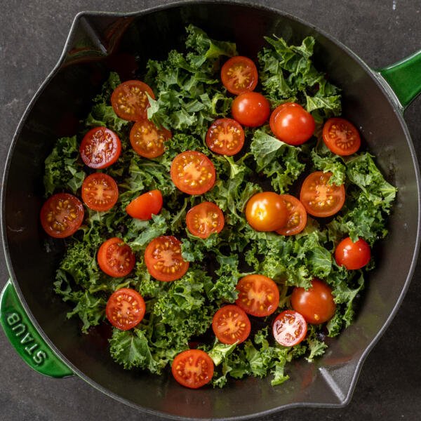 Kale and cherry tomatoes in a pan.