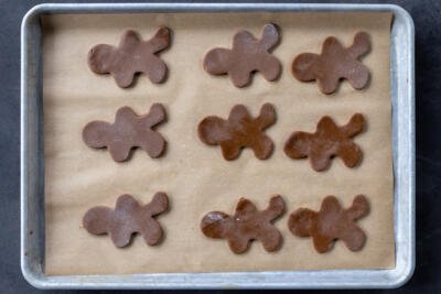 Cut out Gingerbread Cookie cut out on a baking sheet.