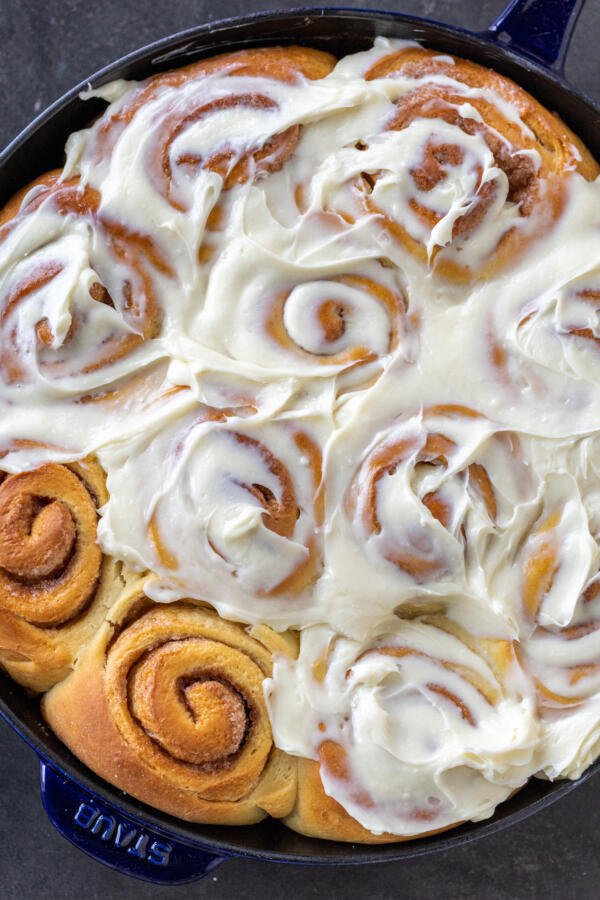 Cinnamon rolls with icing in a baking pan. 