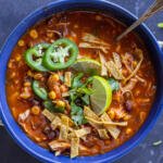 A bowl with Chicken Tortilla Soup and toppings.