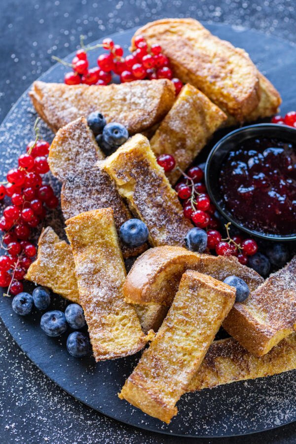 French Toast Sticks on a serving tray with dipping and berries. 