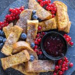 French Toast Sticks with berries on a serving tray.