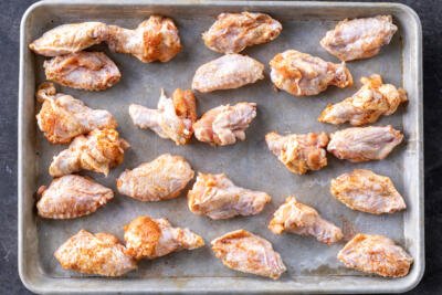 Seasoned wings on a baking pan.