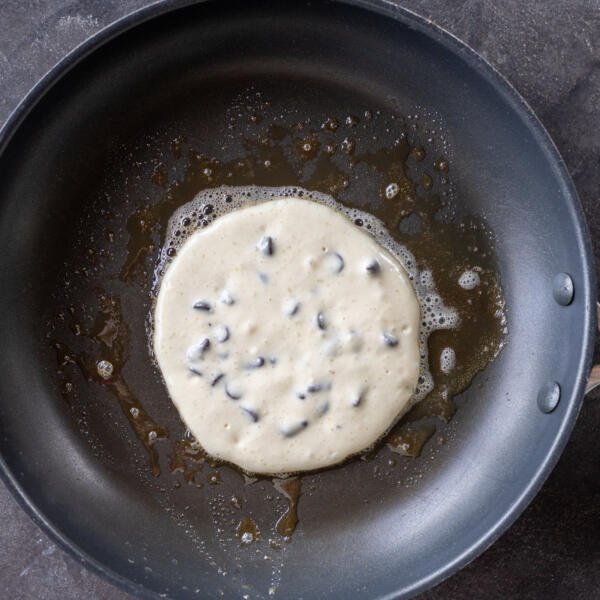 Chocolate Chip Pancakes on a pan with melted butter.