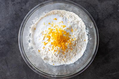 Dry ingredients and orange zest in a bowl.