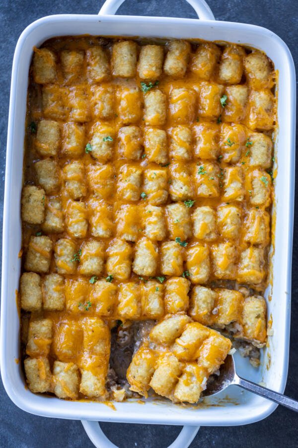 Tater Tot Casserole with a serving spoon in it.