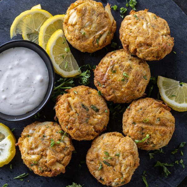 Air Fryer Crab Cakes with dipping sauce and lemons.